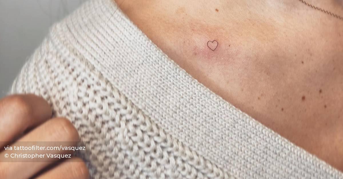 Tiny minimalistic heart tattoo located on the