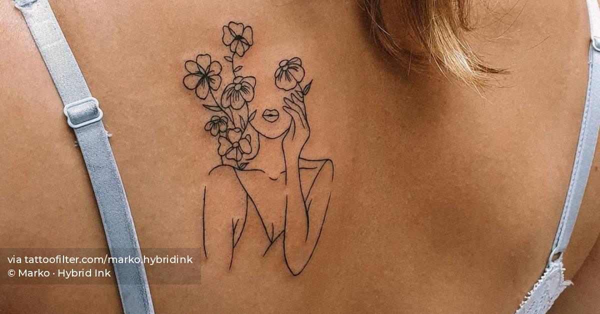Fine line flower head woman tattooed on the shoulder