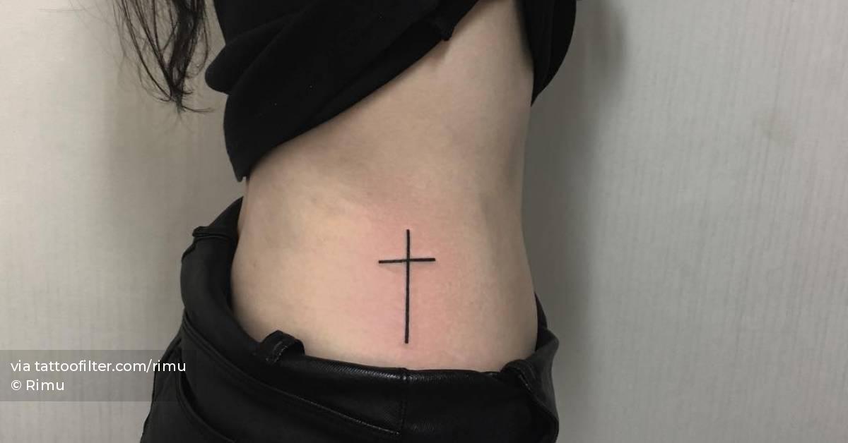 Tattoo of a minimalistic cross located on the waist.