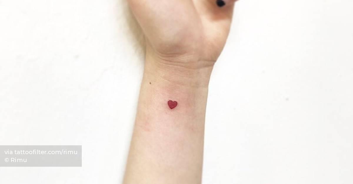 Tiny red heart tattoo placed on the wrist, minimalistic
