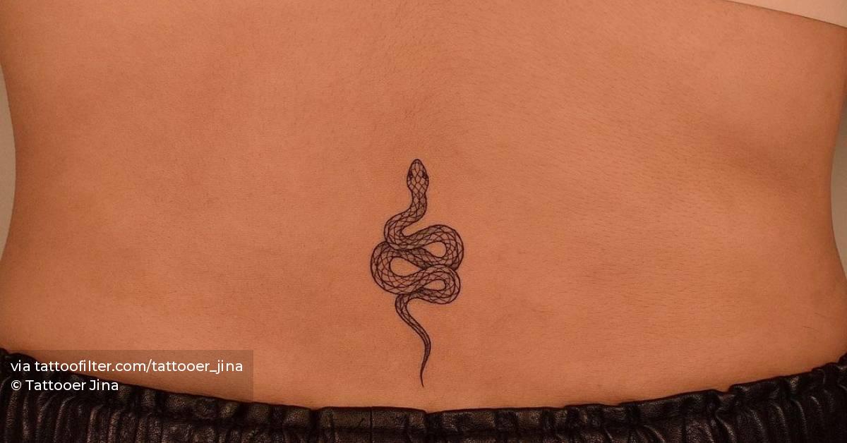 Fine line snake tattoo on the lower back.