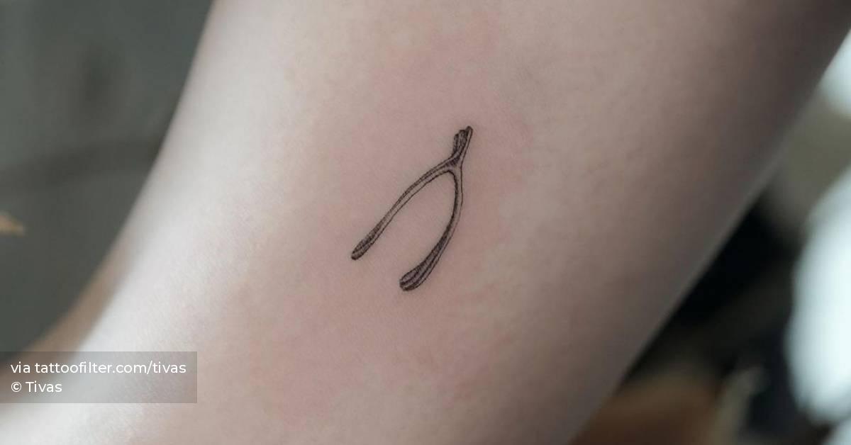Microrealistic style wishbone tattoo located on the