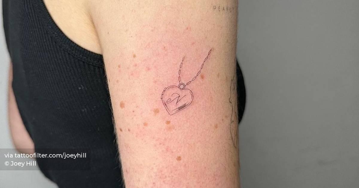 Single needle heart pendant tattoo located on the upper