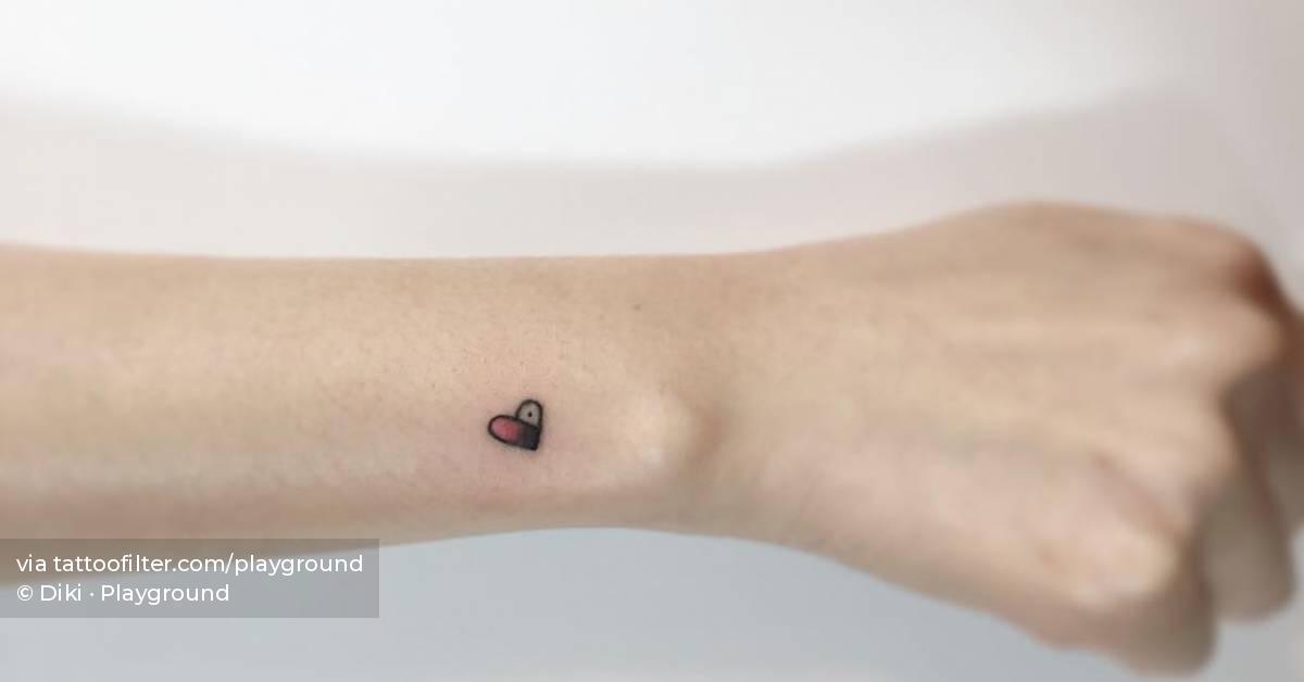 Minimalistic style heart tattoo located on the wrist.