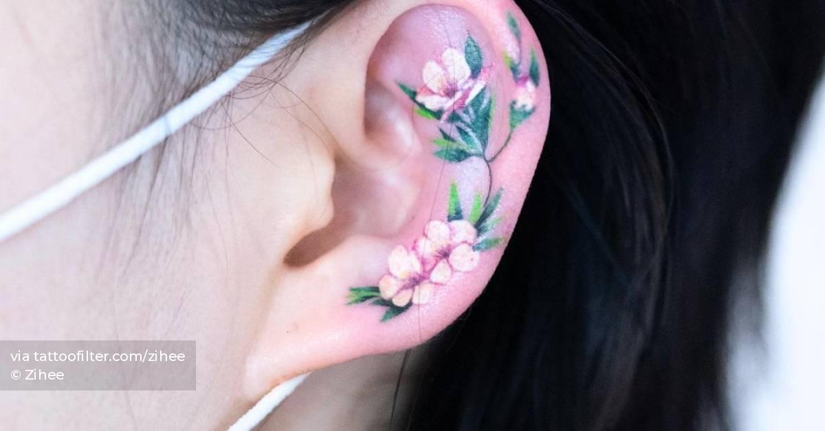 Dog rose tattoo located on the ear, illustrative style.