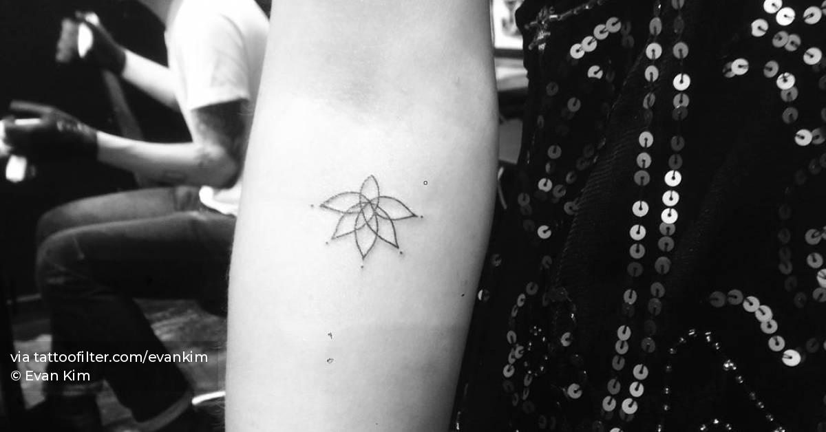 Fine line style lotus flower tattoo located on the