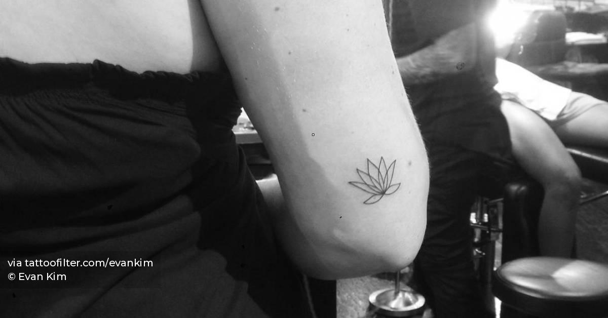 Fine line lotus flower tattoo located on the tricep.