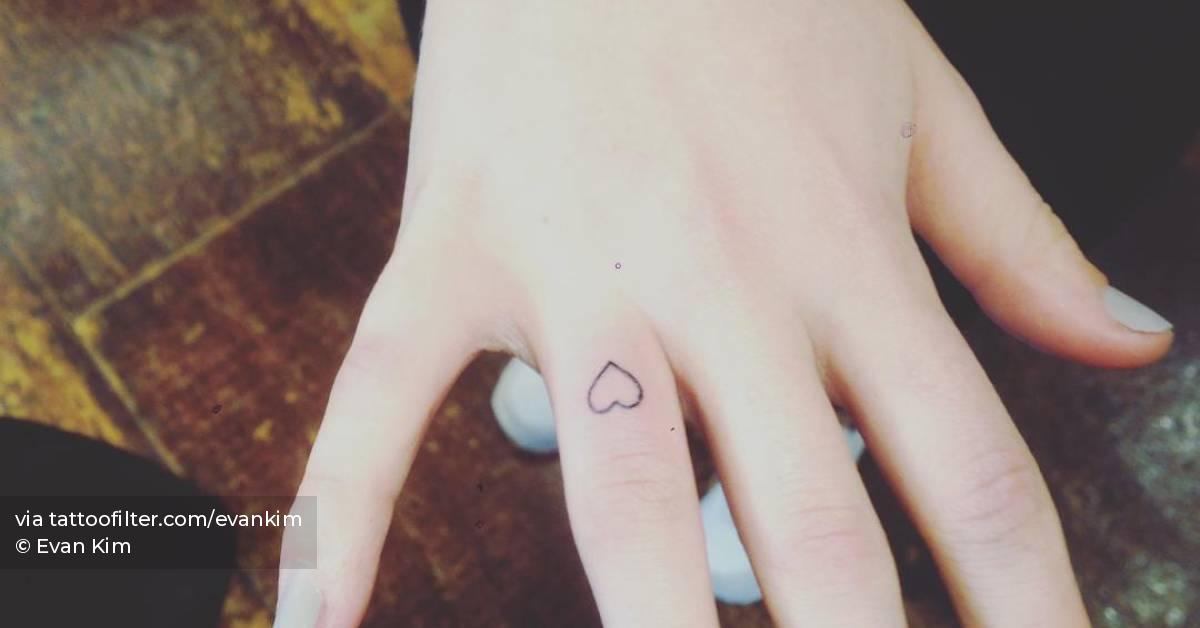 Tiny minimalistic heart tattoo located on the finger.