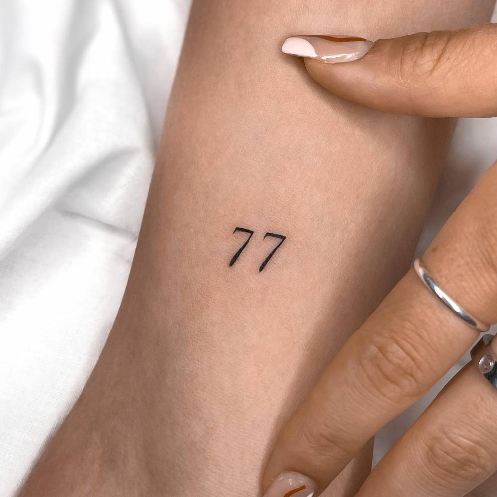 Number 77 Tattooed On The Inner Arm 