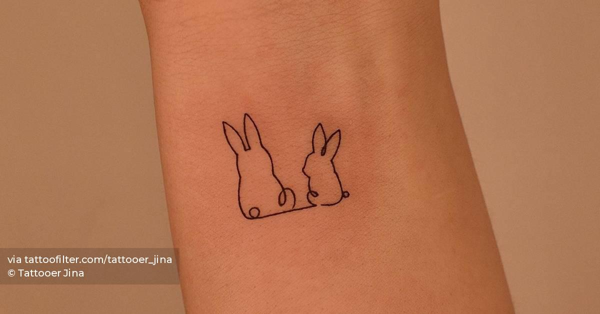 One line rabbits tattoo located on the wrist.