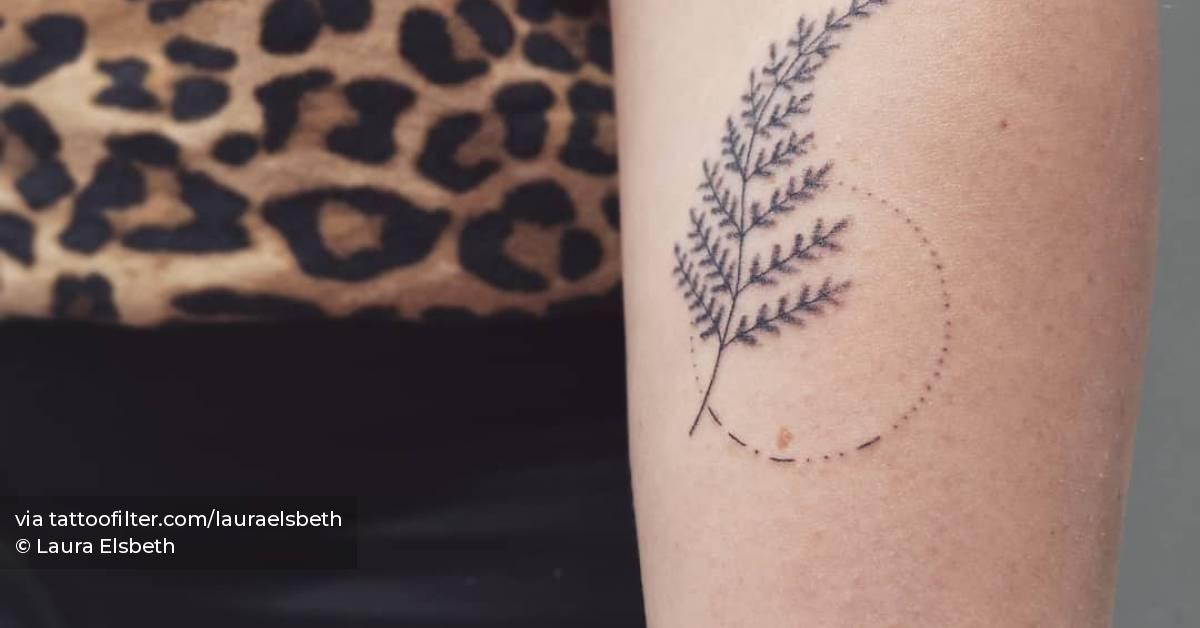 Hand poked fern frond tattooed on the inner forearm.