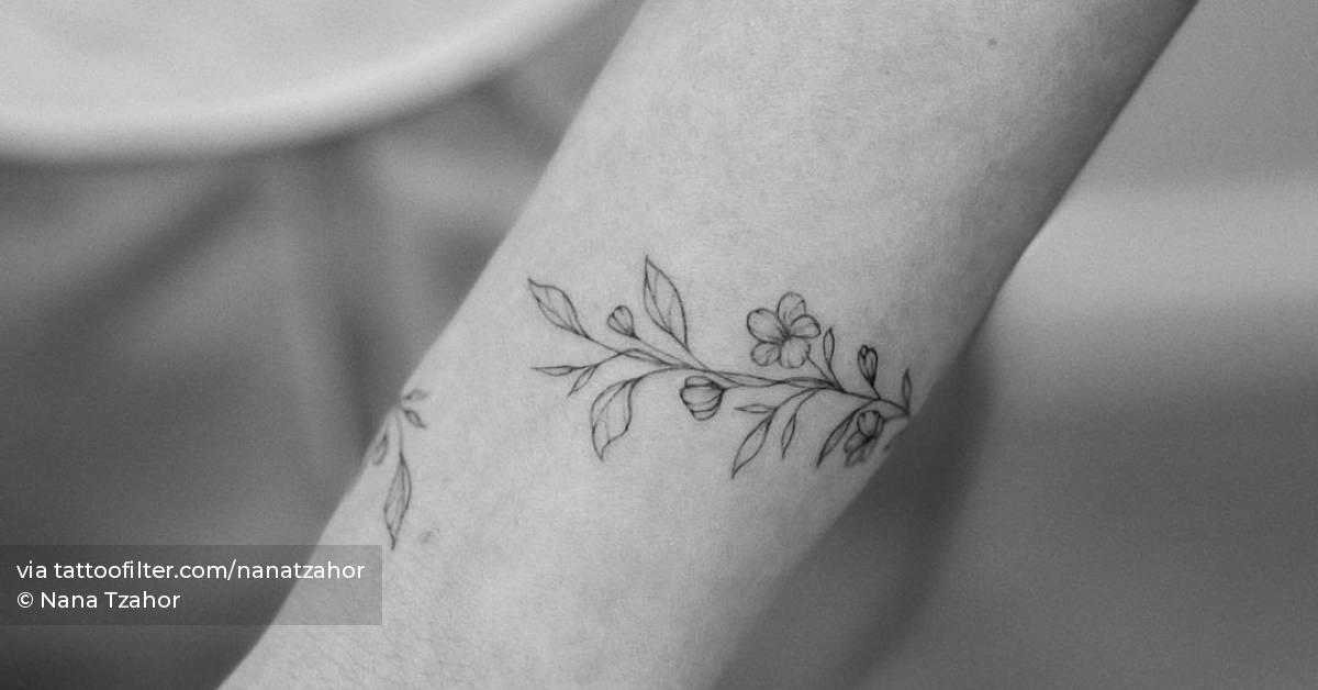 Fine line flower bracelet tattoo located on the wrist.