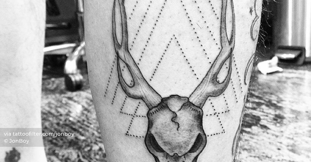 Deer skull tattoo located on the calf, illustrative