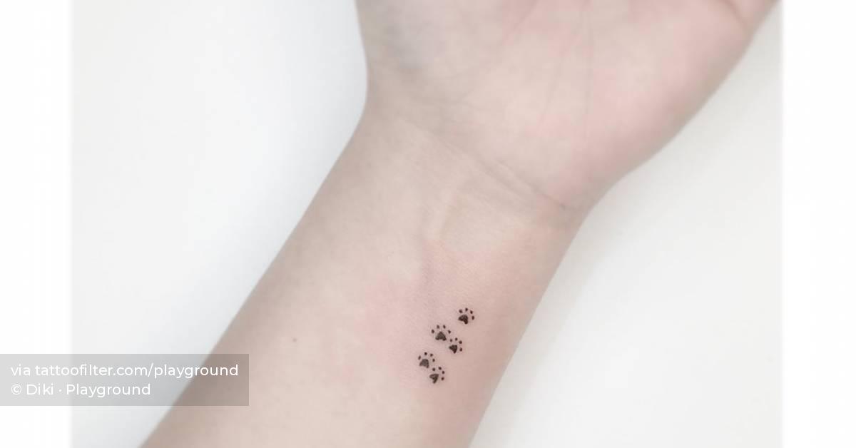 Tiny dog paws tattooed on the wrist, minimalistic
