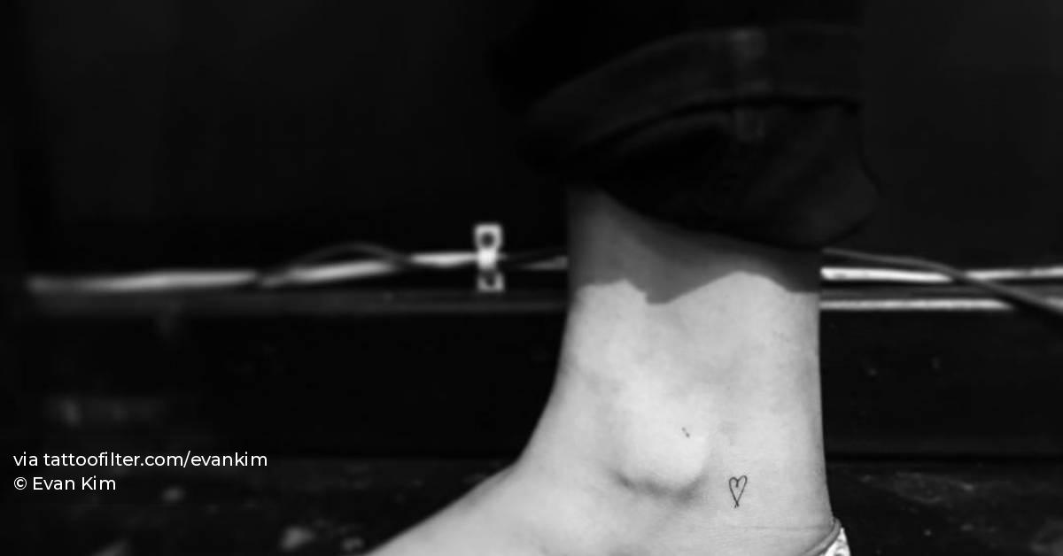 Tiny minimalistic heart tattoo located on the ankle.