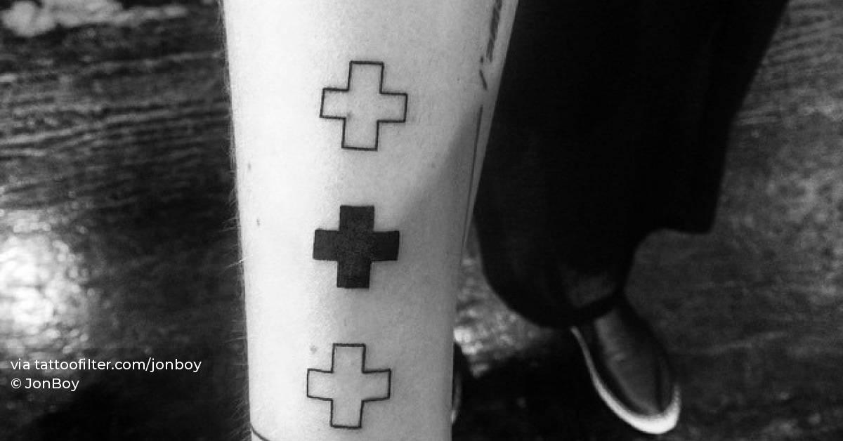 Three plus signs tattooed on the wrist.