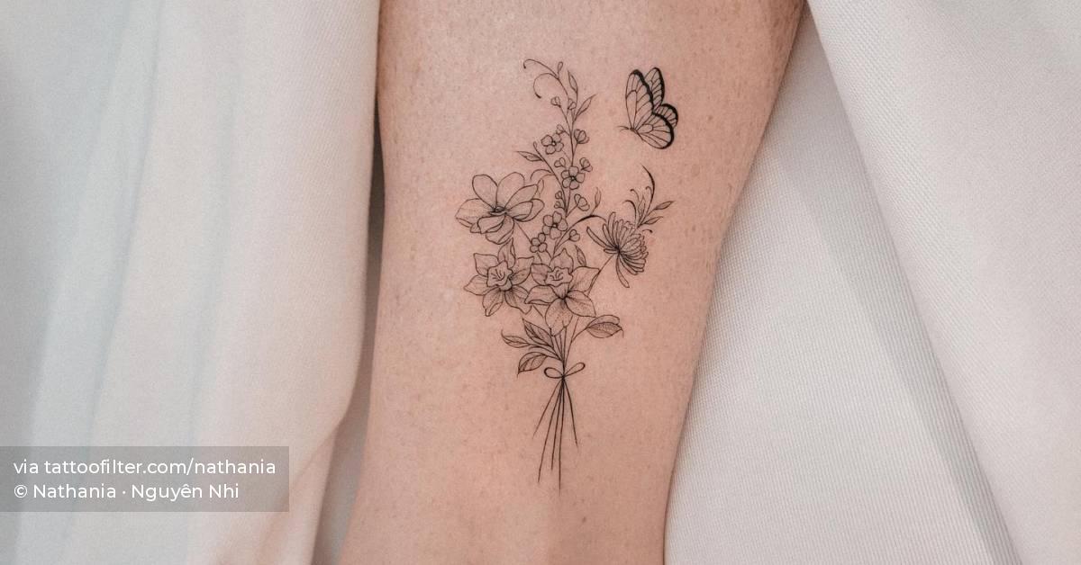 Fine line flower bouquet tattoo placed on the ankle.