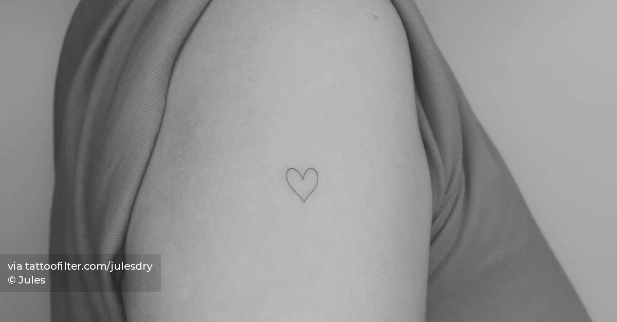 Tiny minimalistic heart tattoo located on the upper