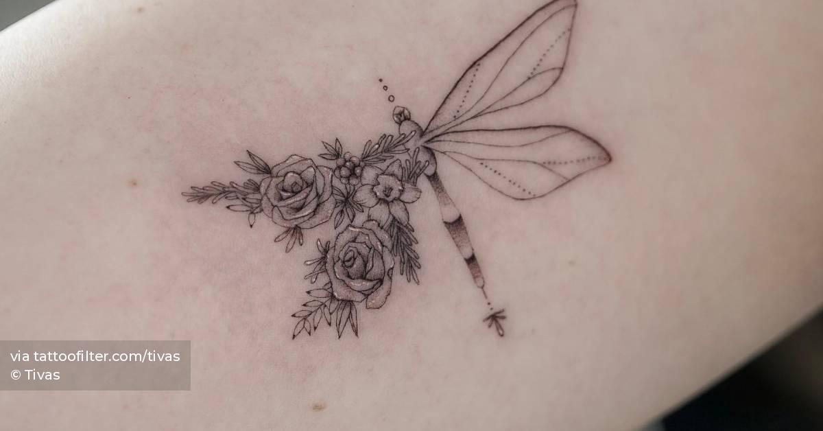 Floral dragonfly tattoo located on the inner arm.
