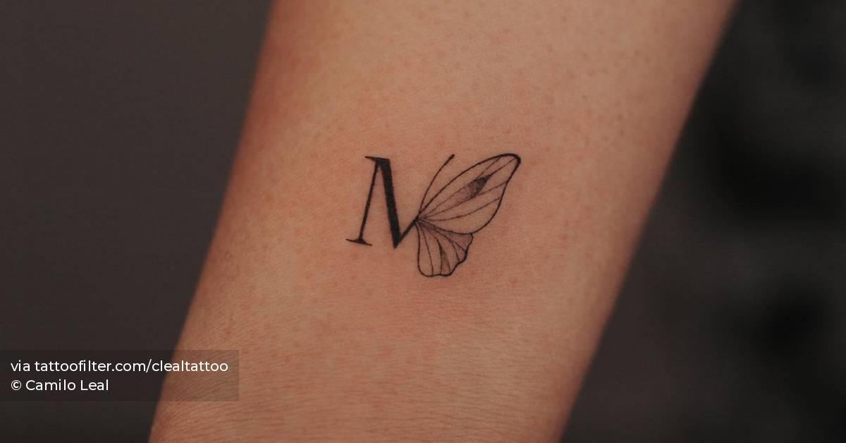 Tattoo of the letter "M" and butterfly located on the