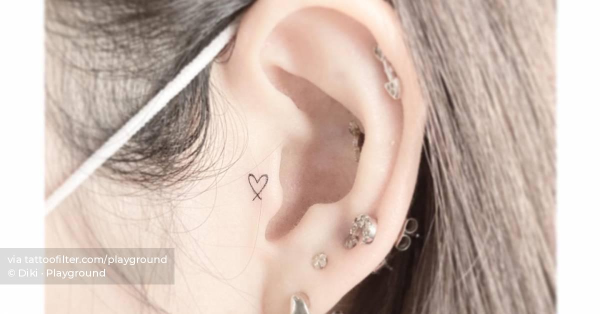 Tiny minimalistic heart tattoo placed on the ear.