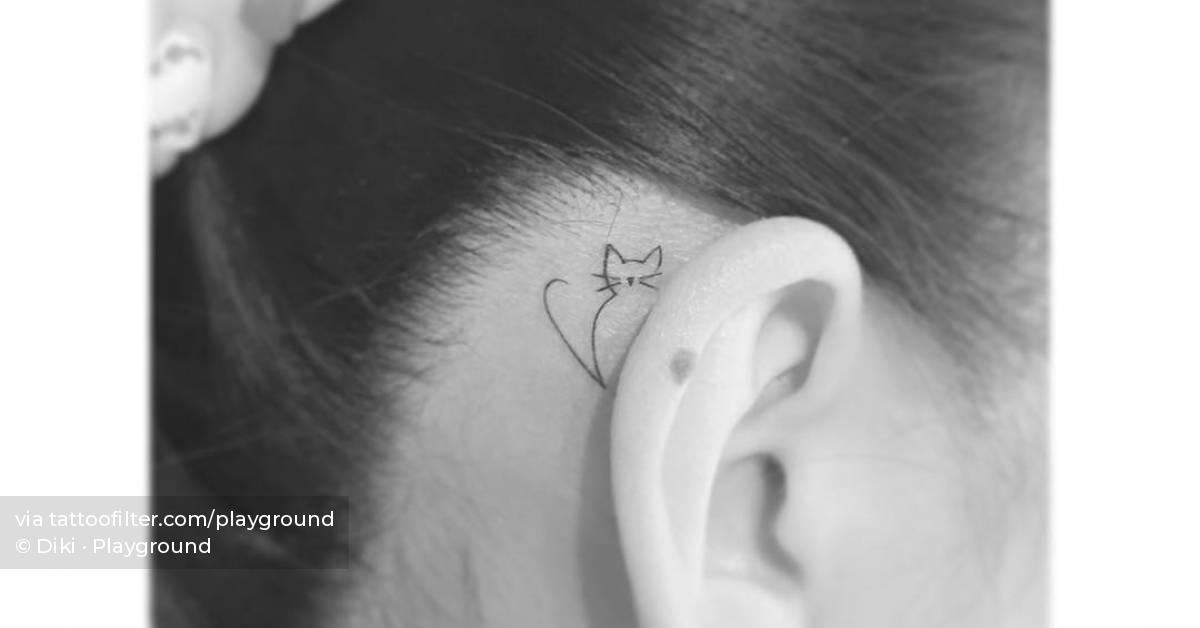 Cute minimalistic cat tattoo placed behind the ear.