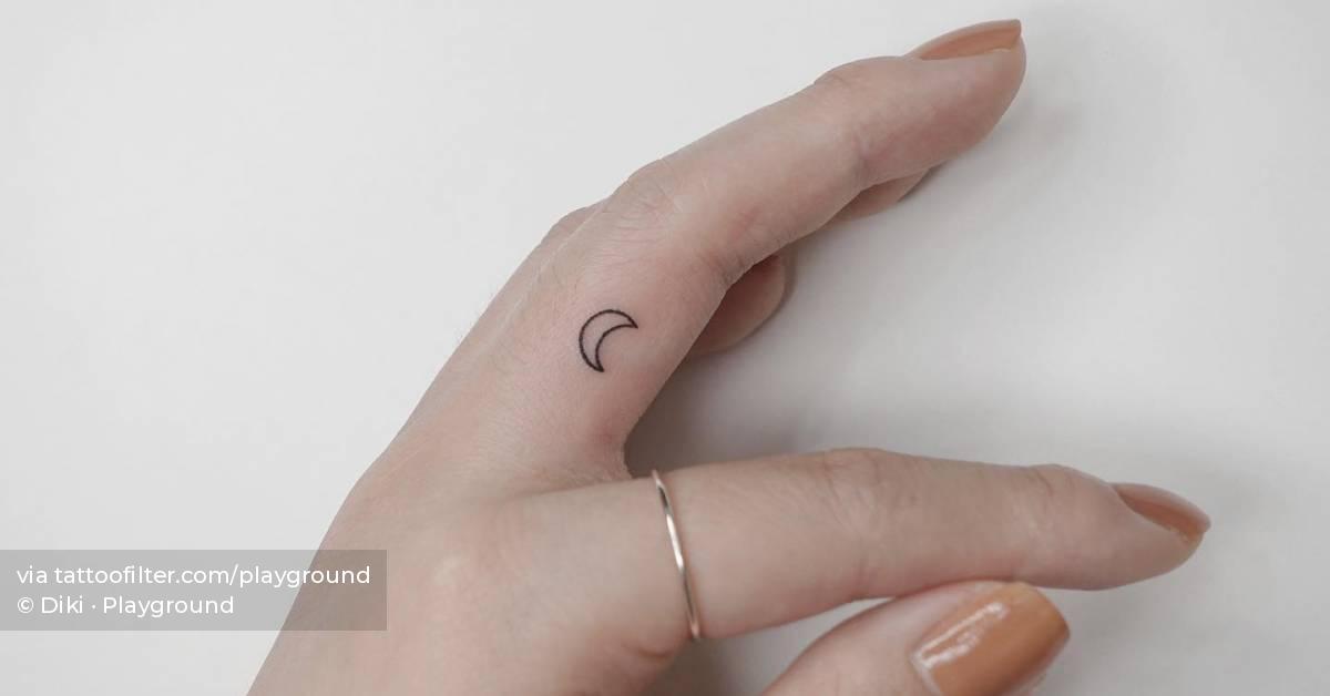 Minimalistic style crescent moon tattoo located on the