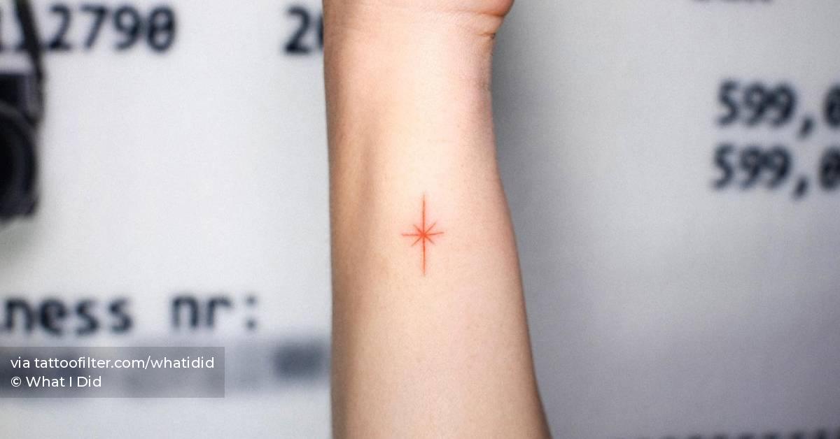 Red north star tattoo done on the wrist, minimalistic