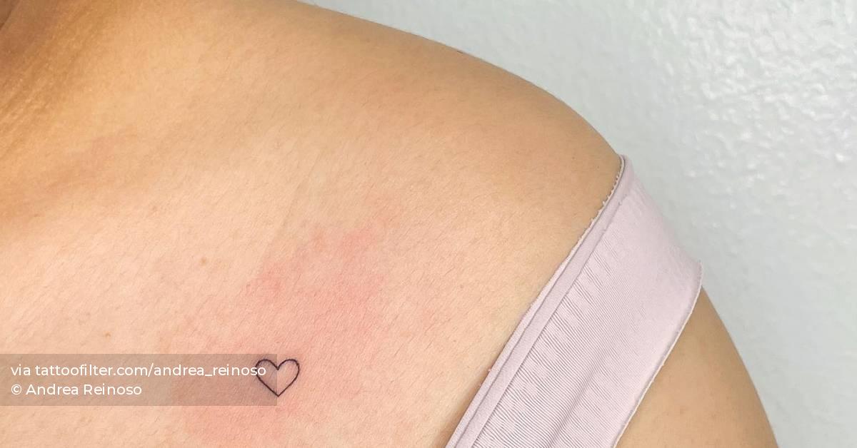 Tiny minimalistic heart tattoo placed on the chest.