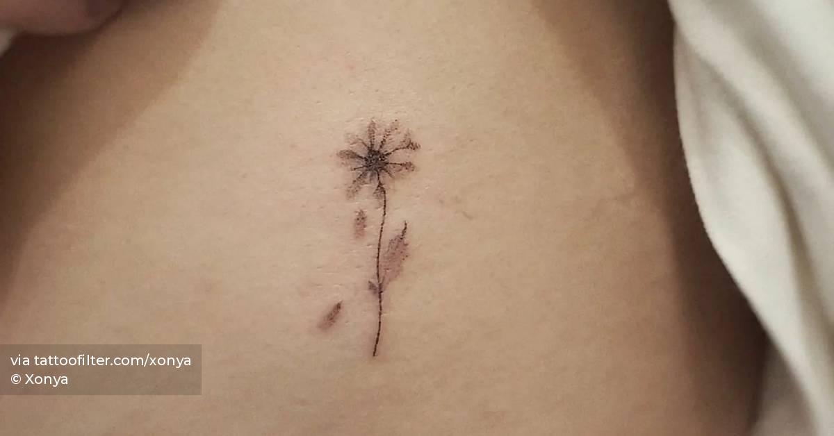 Hand poked daisy flower tattoo done on the rib.