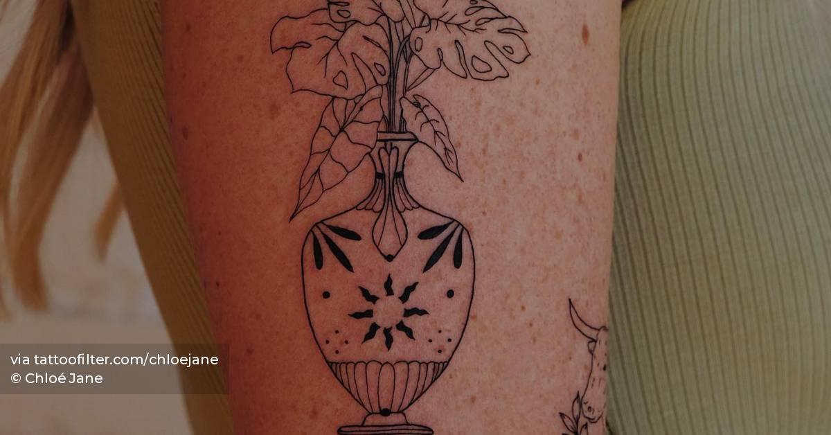 Plant vase tattoo located on the upper arm.