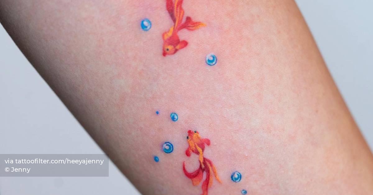 Watercolor style goldfish tattoo located on the inner
