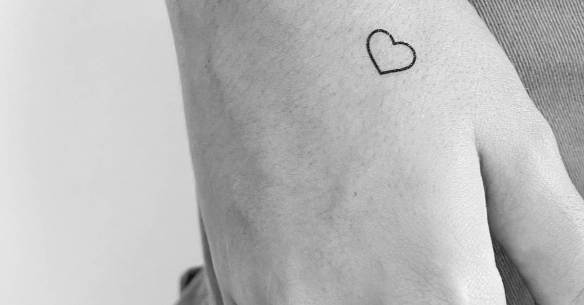 Tiny minimalistic heart temporary tattoo located on the