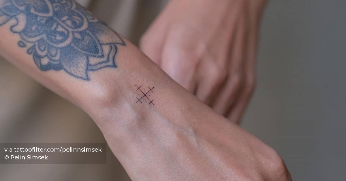 Fine line style little ornament tattoo located on the