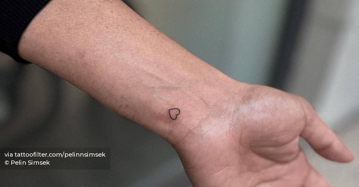 Minimalistic style heart tattoo placed on the wrist.