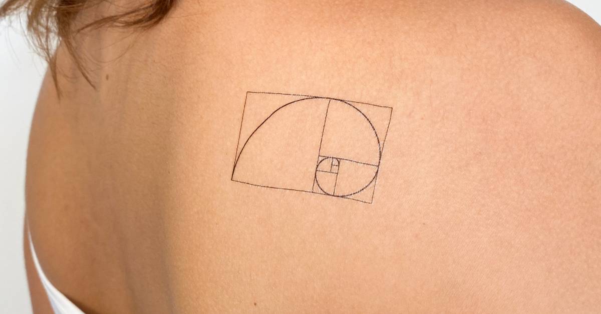 Golden spiral temporary tattoo located on the shoulder