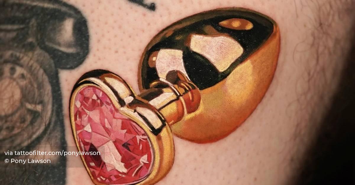 Micro-realistic style butt plug tattoo located on the