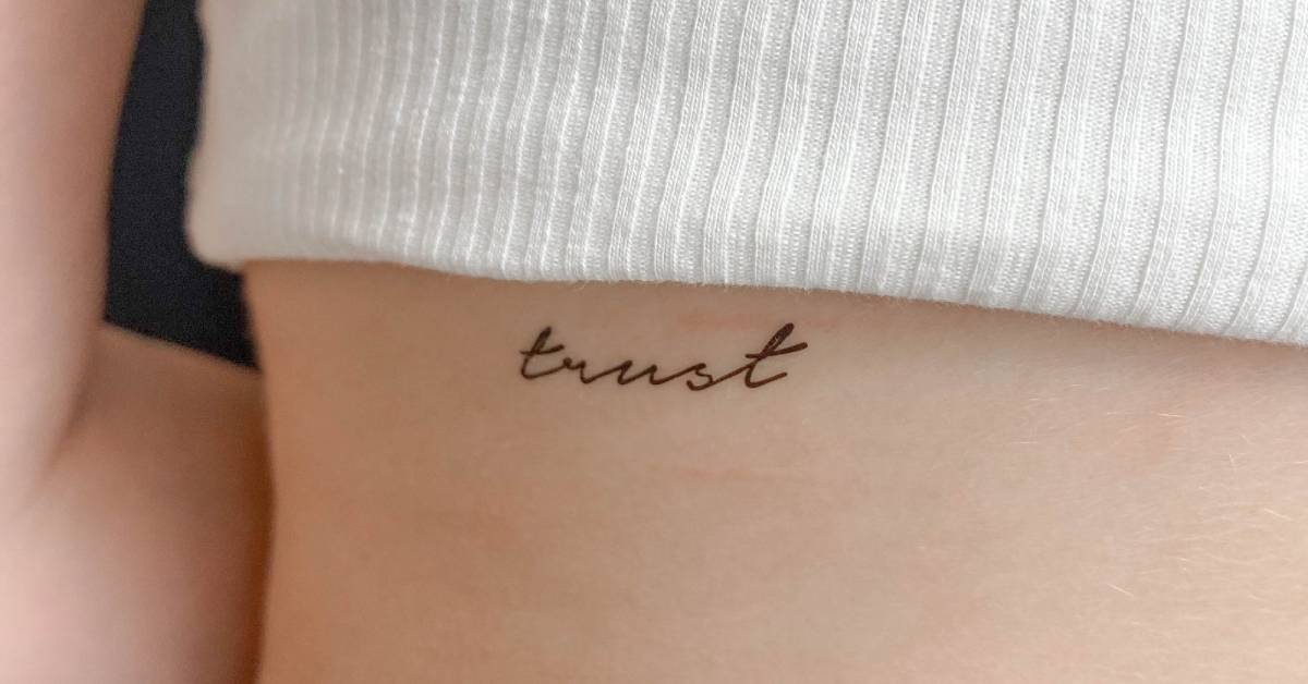 Tattoo of the word trust handwritten on the back 