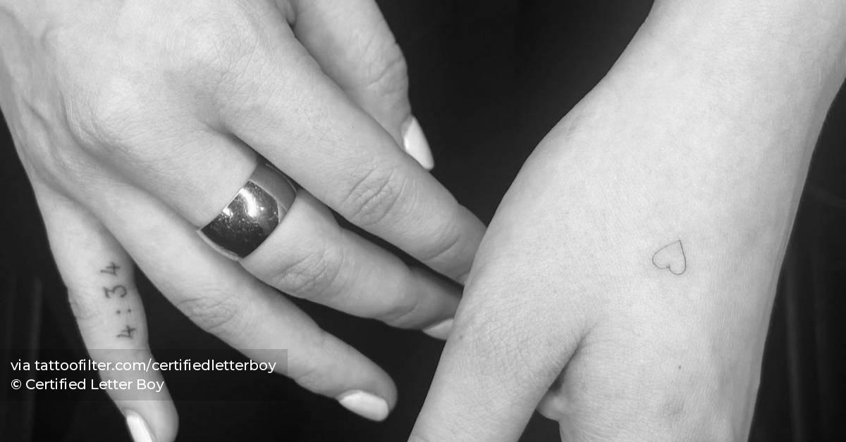Tiny minimalistic heart tattoo placed on the hand.