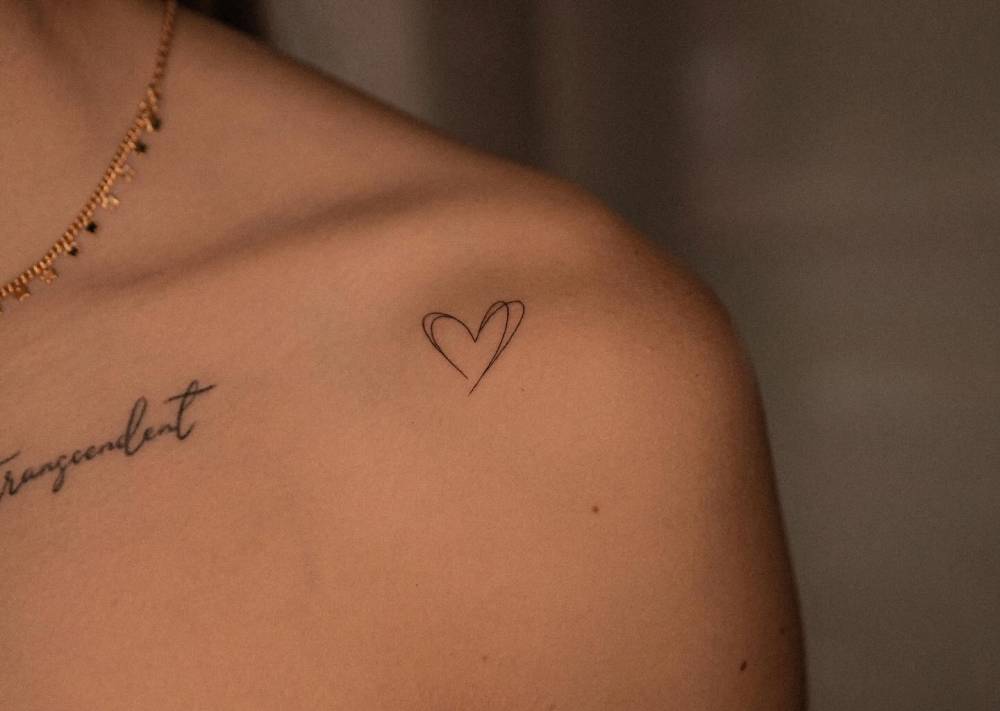 Fine line style heart tattoo done on the shoulder.