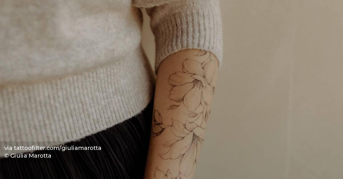 Illustrative style magnolia flowers tattooed on the