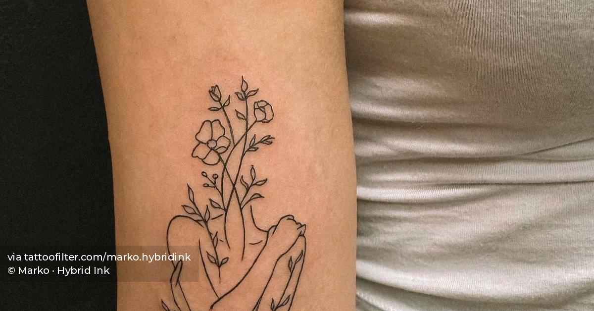 Flower head woman tattoo located on the bicep, fine