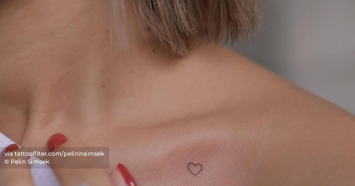 Tiny minimalistic heart tattoo placed on the