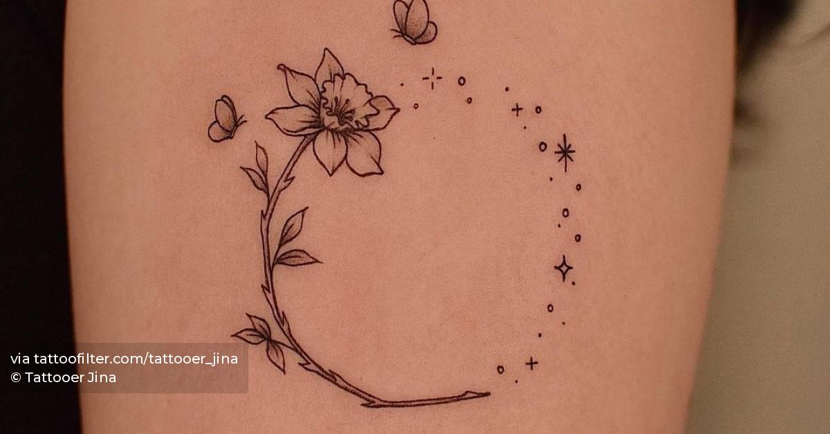 Fine line narcissus flower tattoo on the upper arm