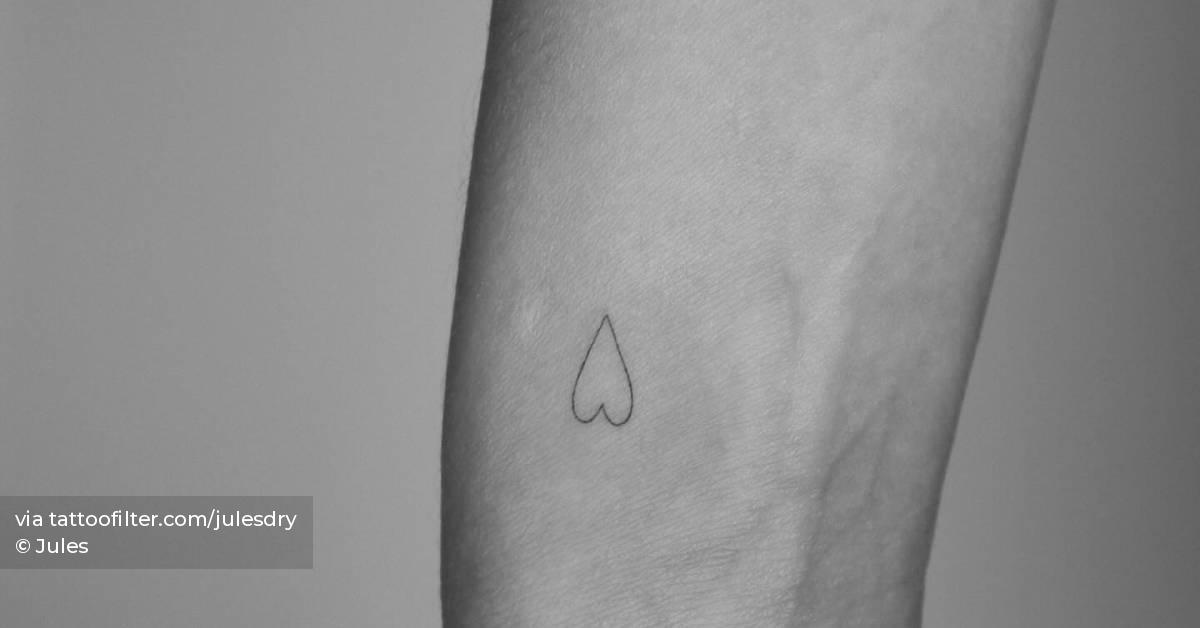 Minimalistic style heart tattoo located on the wrist.