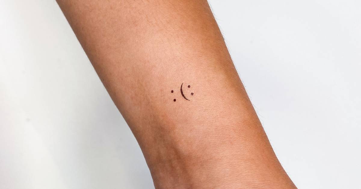 Happy and sad smiley face temporary tattoo done on the