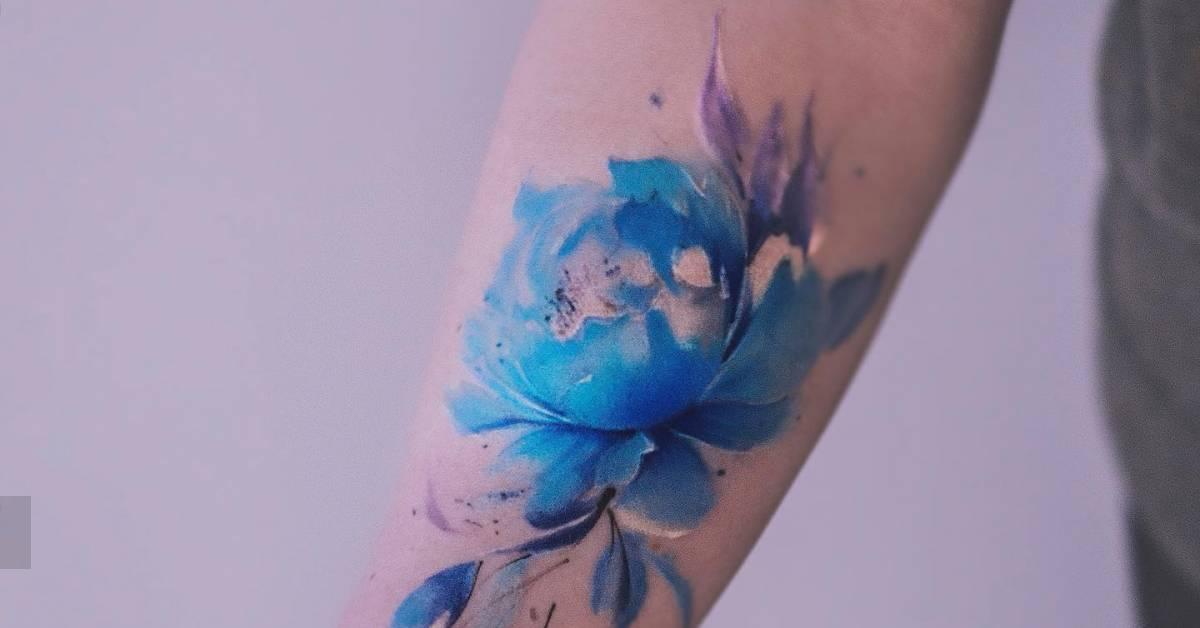 Watercolor style blue peony tattoo located on the inner