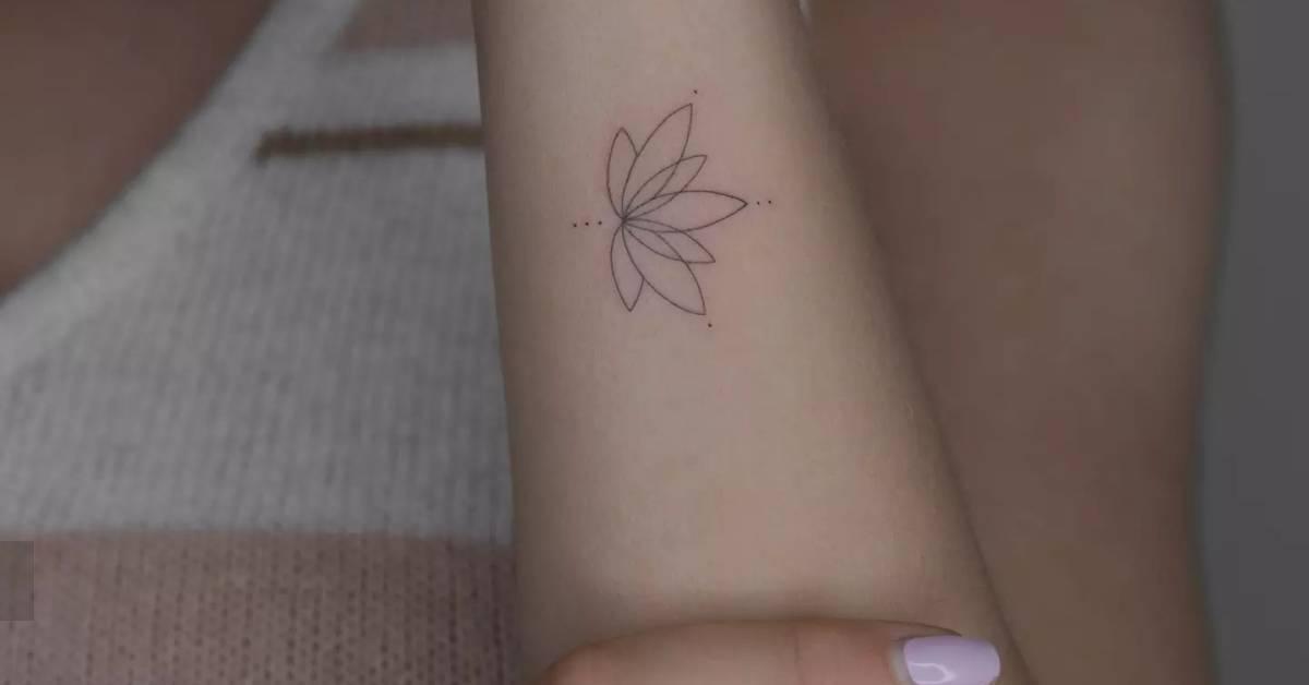Fine line style lotus flower tattoo placed on the