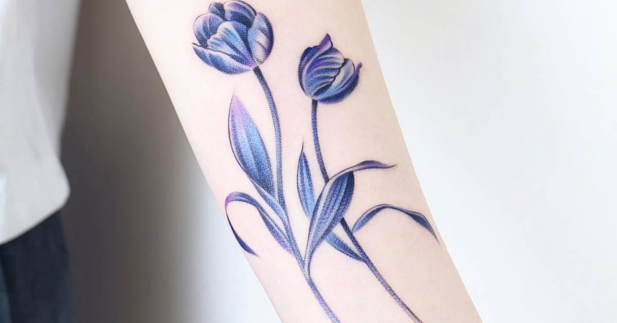 Watercolor style blue tulips tattoo placed on the inner