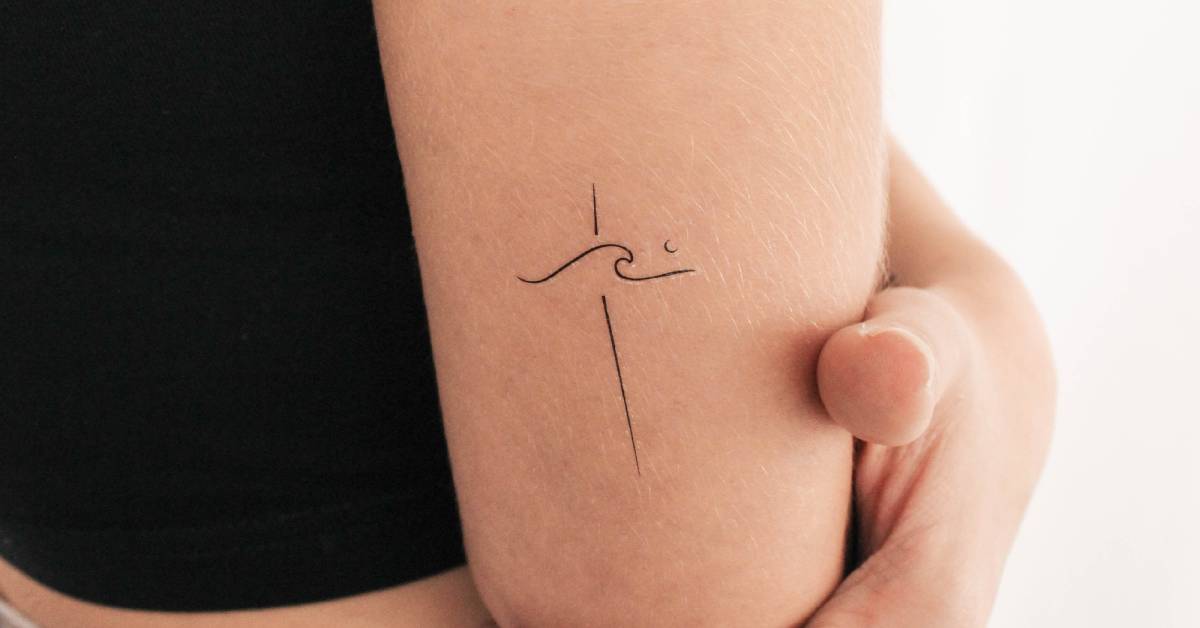 Minimalist wave cross temporary tattoo located on the